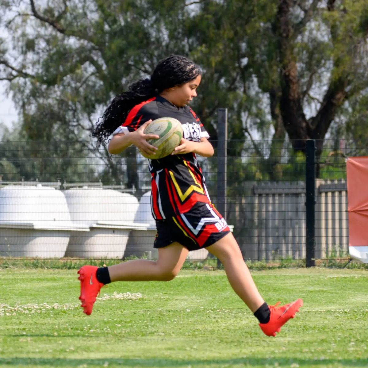 A BESA learner running with a touch rugby ball